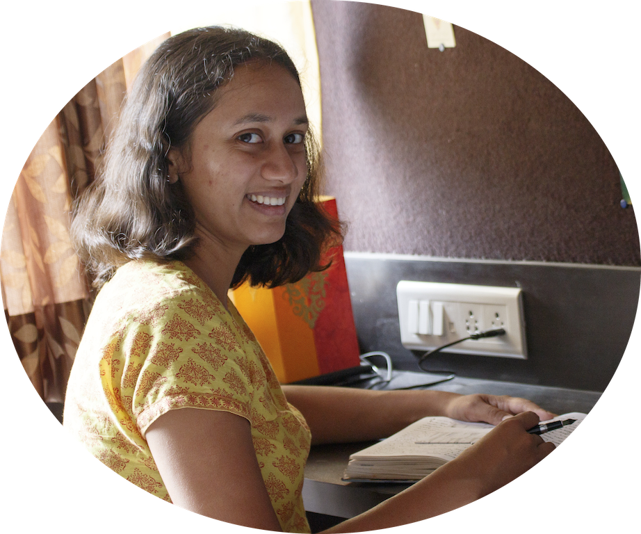 Varsha Seshan at a table, writing