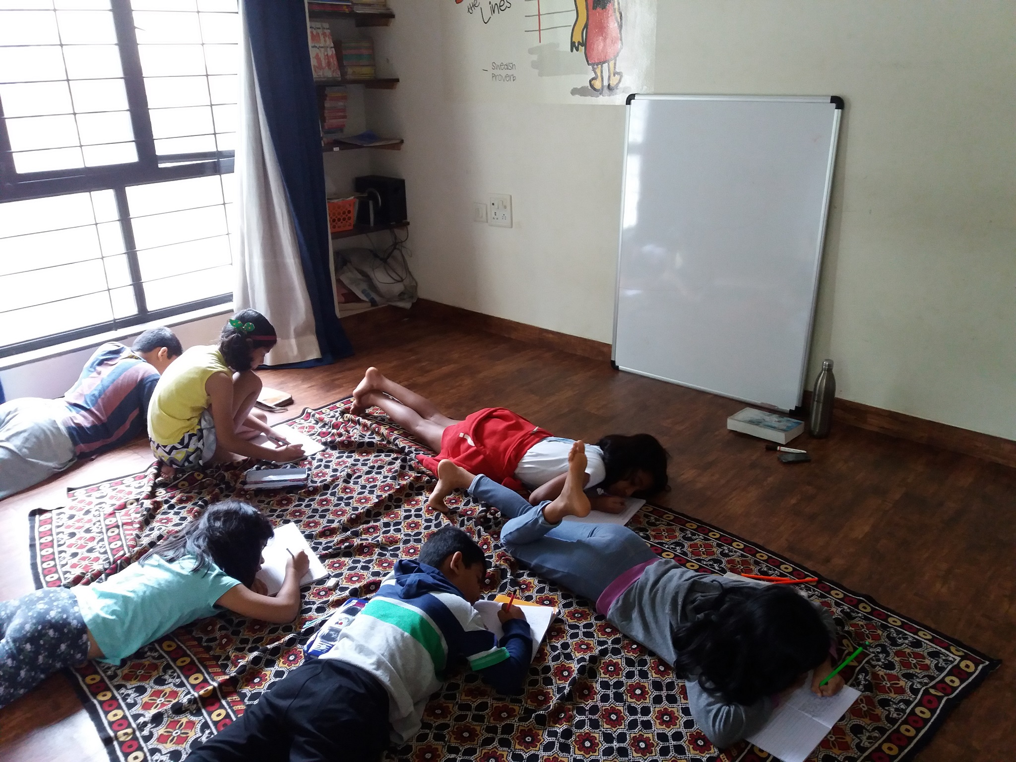 Children lying down and writing