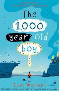 A boy and a cat in the middle distance (unclear), between a cliff with birds and another cliff with a burning house.
Text - 'The 1,000 year old boy'