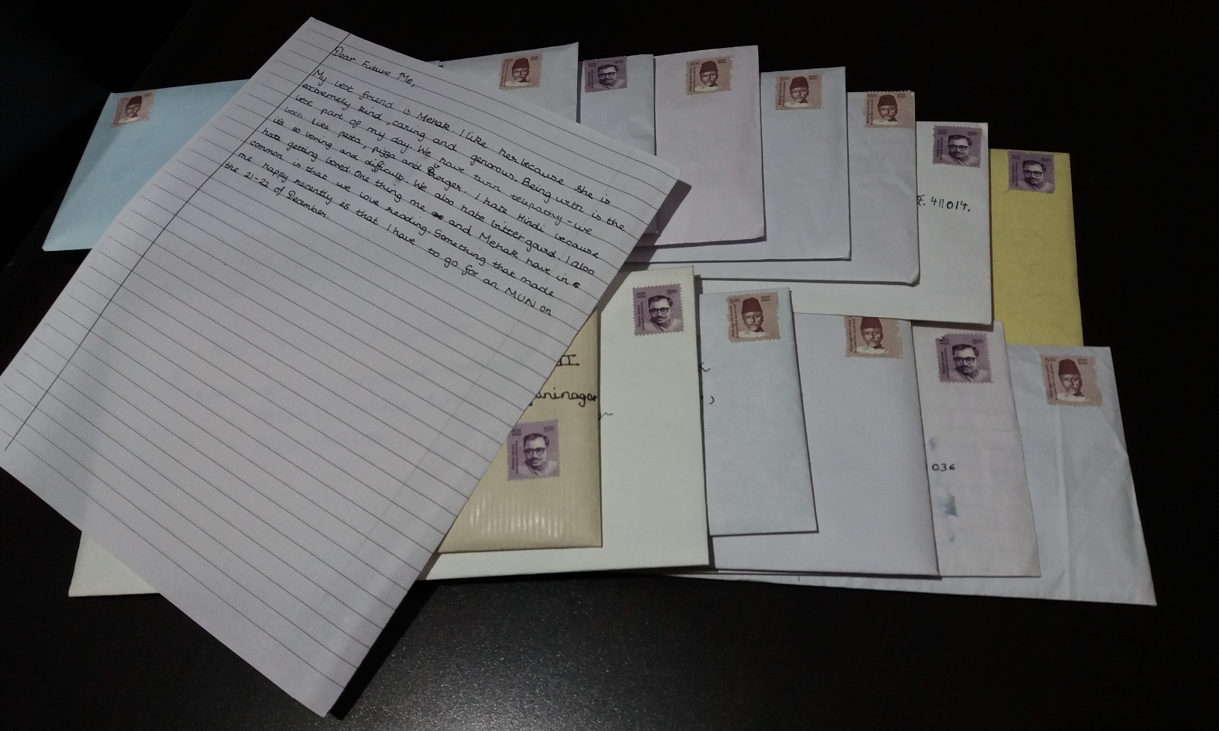 Two piles of stamped envelopes, a handwritten letter on top to hide the addresses.