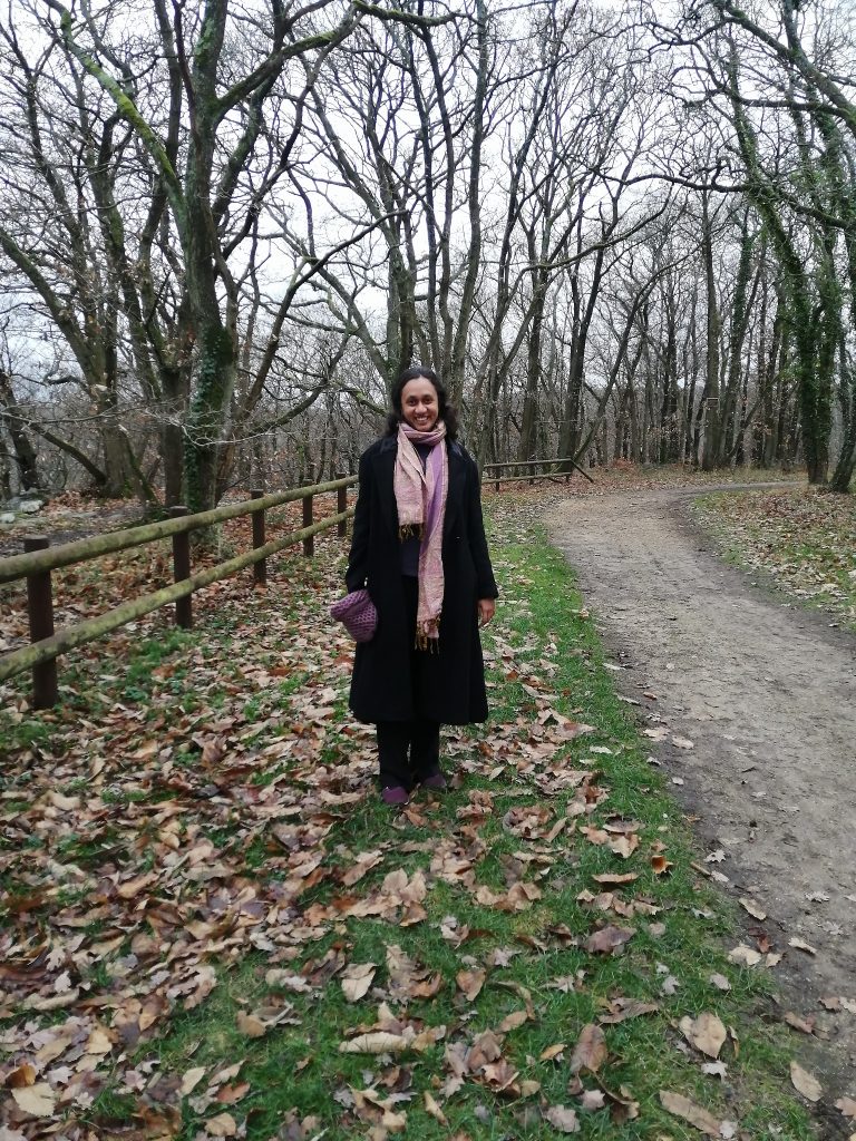 Varsha in the woods, treeless trees in the background, leaves on the grass