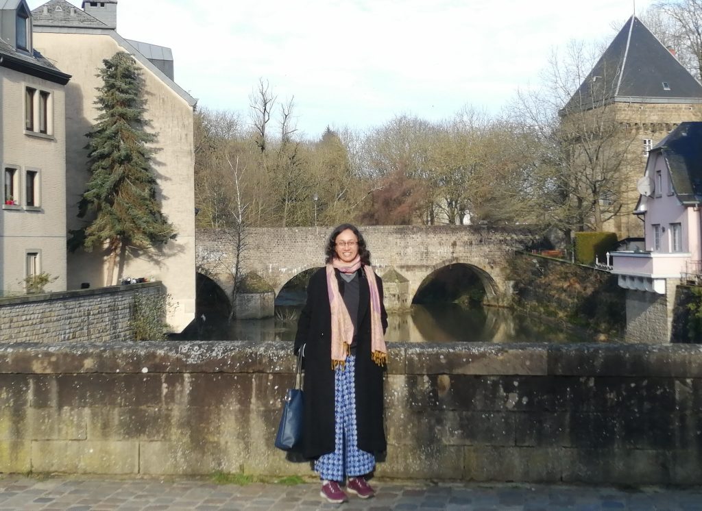 Varsha on a bridge, an arched bridge in the background