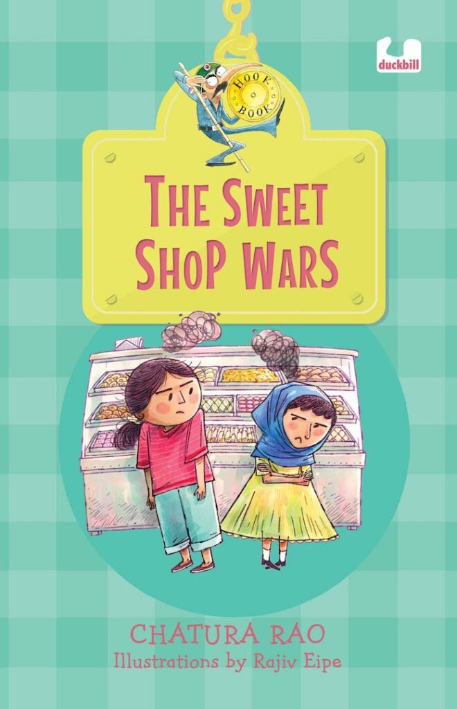 Book cover
The Sweet Shop Wars
Chatura Rao
Illustrations by Rajiv Eipe
Illustration of two girls with angry black clouds above their heads in front of a sweet shop counter 